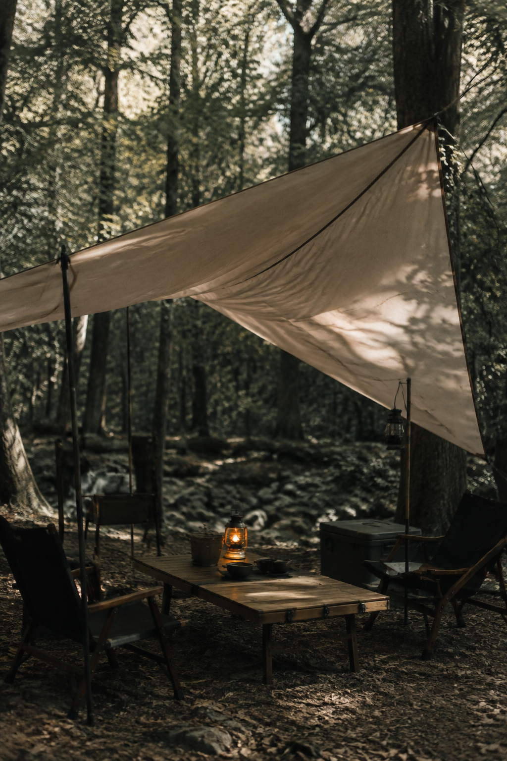 Polycotton wing tarp stretched between trees over a camp table